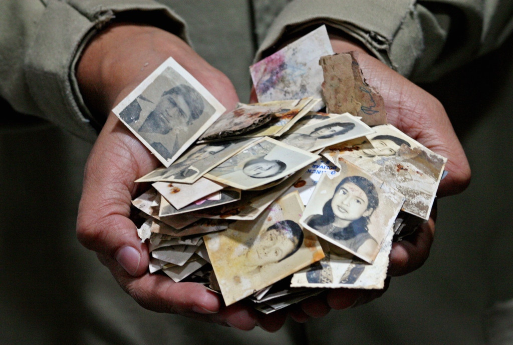  Фонд криминалистической антропологии Гватемалы разбирает сумки с нерассортированными фотографиями из Национального архива полиции, исследуя зверства и убийства, совершенные полицейскими во время 30-летней гражданской войны в Гватемале. 27 июля 2006 г. Фото: Сара Л. Вуазен/The Washington Post/Getty Images.